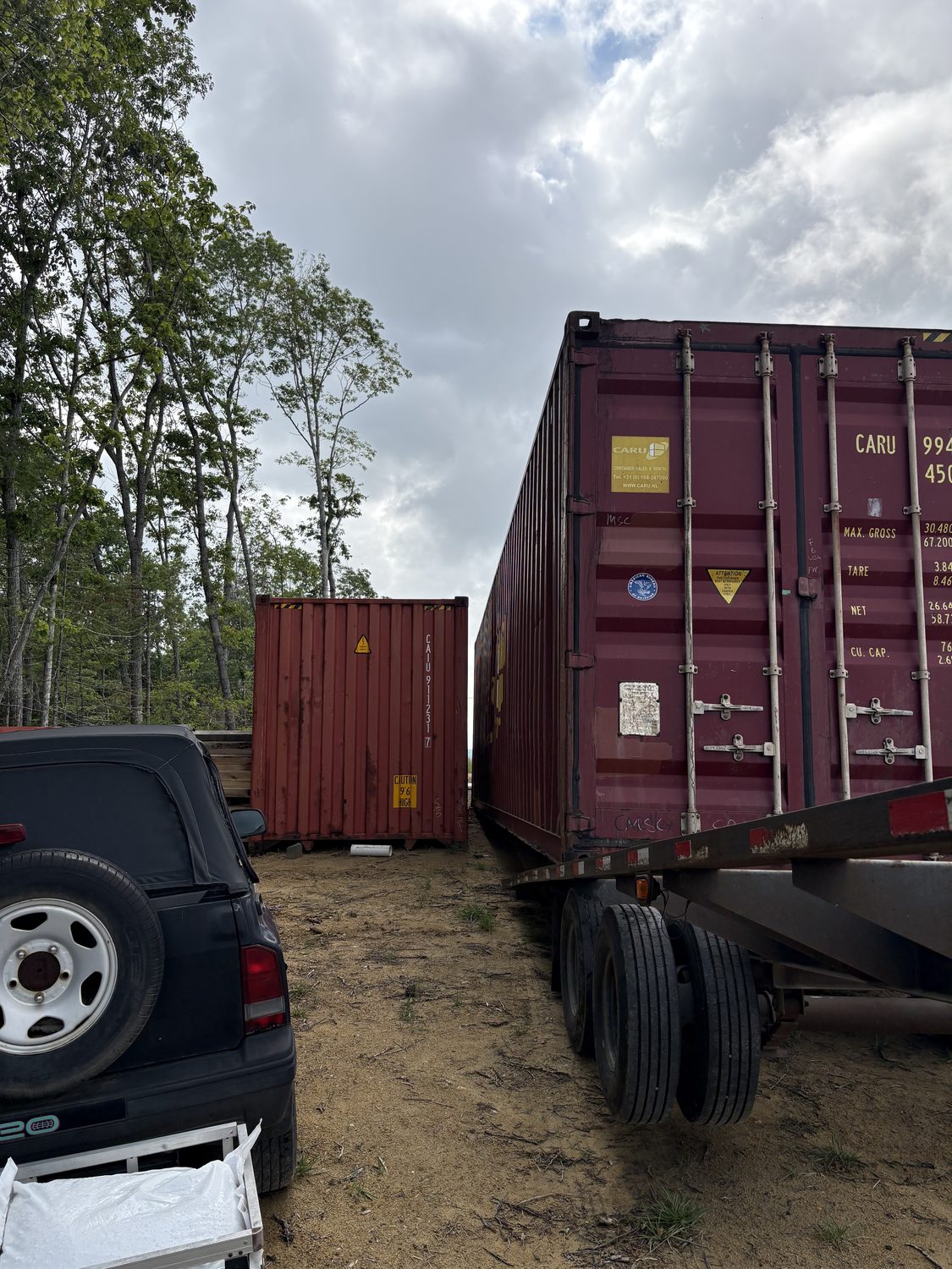 Tilt-bed truck delivering and leveling a container near Hillsville, VA